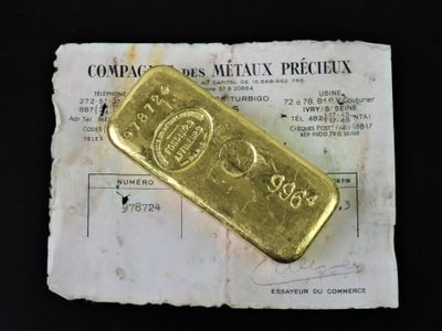 un lingot d'or posé sur une feuille de papier
