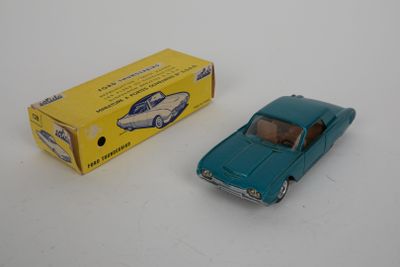 une petite voiture bleue et une boîte jaune posées sur une surface blanche
