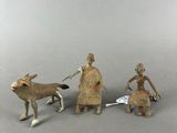 trois figurines représentant une femme, un homme et un chien