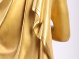 gold statue of a woman holding a glass of wine in her hand