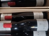 several bottles of wine are in a cardboard box on a table