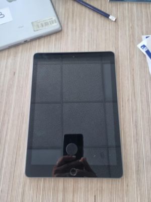 une personne en train de prendre une photo d'une tablette posée sur une table
