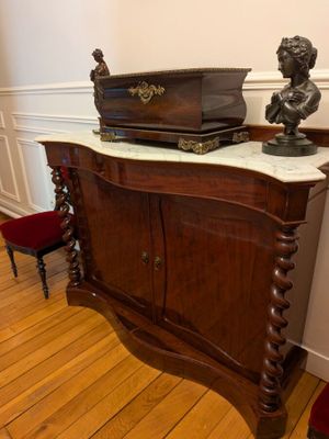 a wooden cabinet with a marble top and a busturine on top