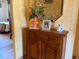 un vase de fleurs posé sur une commode dans une pièce