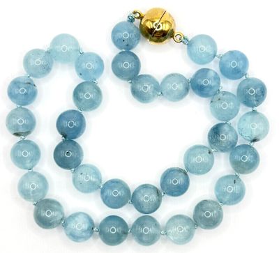 Gros plan sur un collier composé de perles bleues sur fond blanc