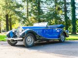 a blue vintage car parked on the side of the road