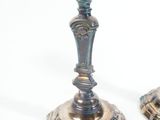 two silver candlesticks on a white background