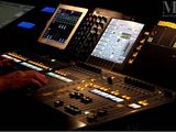 a man that is sitting in front of a sound board