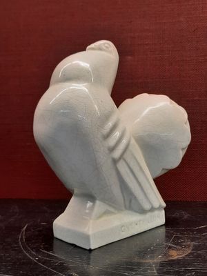 a white sculpture of a bird sitting on a table