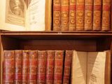 many old books on a wooden shelf in a room