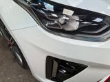 a close up of a white car with a red stripe on it