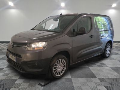 la camionnette grise est garée sur un sol en damier dans le garage