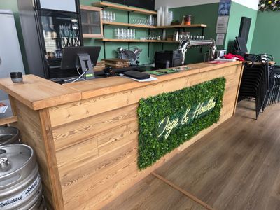 un bar en bois dont le comptoir est orné d'un mur recouvert de mousse
