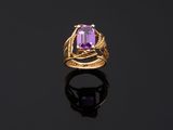 a gold ring with an amethorate stone in the center