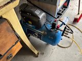 un compresseur d'air bleu posé sur une table en bois
