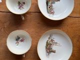 three cups and a saucer are sitting on a wooden table