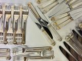 a lot of silverware on a table with a knife and fork
