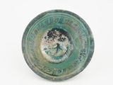 a close up of a green bowl on a white surface