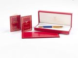 une boîte rouge contenant un stylo et un bloc-notes