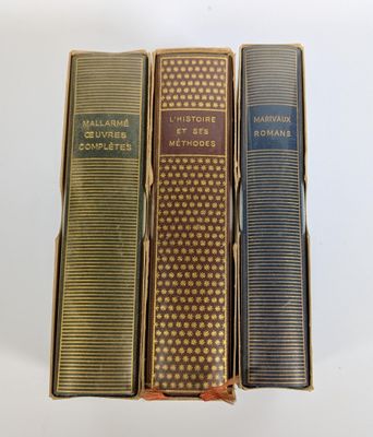 trois livres superposés sur une surface blanche