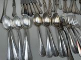a lot of spoons and forks on the table