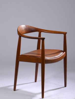 une image représentant une chaise en bois avec une assise en cuir marron