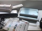 un bureau sur lequel se trouvent un ordinateur portable, une imprimante et d'autres appareils électroniques