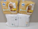 two packs of baby diapers sitting on top of a white counter