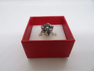 une bague dans une boîte rouge posée sur une surface blanche