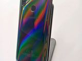 a close up of a cell phone on a stand on a white surface