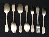 six forks and spoons are lined up on a black surface