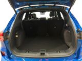 the back of a blue car with its trunk open and the back seats down