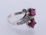 a close up of a ruby and diamond ring on a white background