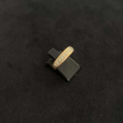 gros plan d'une bague en or avec des diamants sur une surface noire