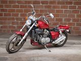 a red motorcycle that is parked in front of a brick wall