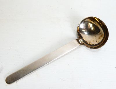 une cuillère posée sur une table blanche