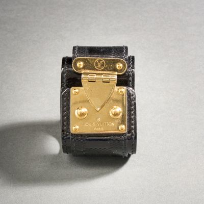 l'image d'une montre noire et or sur une surface blanche