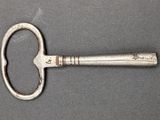 a silver key that is laying on a table