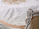 a white bed with a white comforter and a white pillow