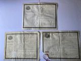trois vieux journaux sur lesquels sont posés une paire de ciseaux