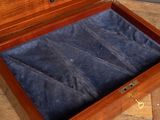 a wooden box with a blue velvet lining inside of it