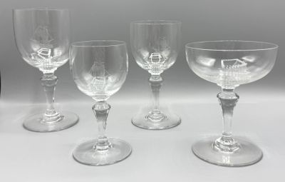 quatre verres à vin vides sont alignés sur une surface blanche