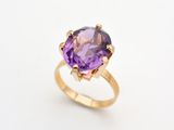 une bague en or jaune sertie d'une pierre violette