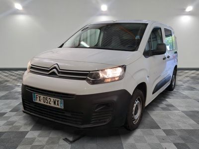 la camionnette blanche est garée sur un sol en damier dans le garage