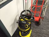 a vacuum cleaner that is on the floor next to a shopping cart