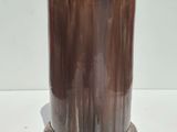 a brown vase on a white table with a white background