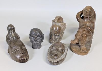 plusieurs figurines sculptées de formes et de tailles variées, posées sur une surface blanche