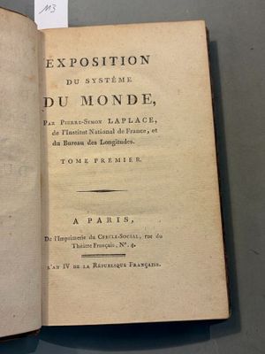 an open book on a table with a piece of paper on it