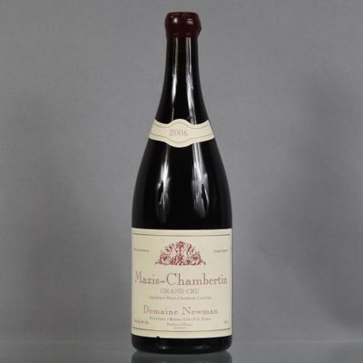 une bouteille de vin posée sur une table à côté d'un verre