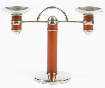 a silver and wood candle holder with two candles on it